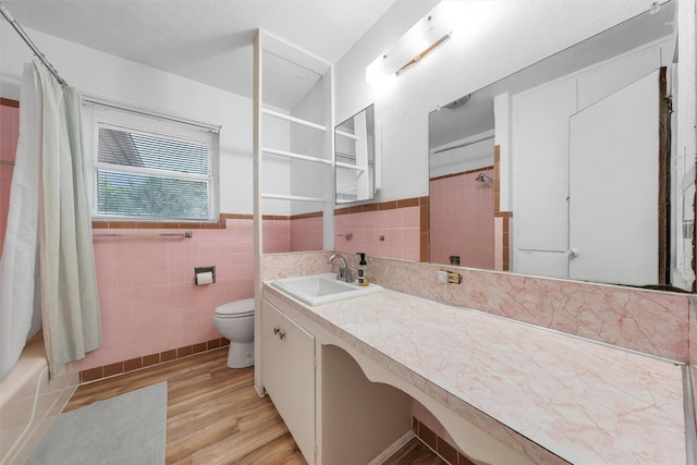 full bath with vanity, wainscoting, wood finished floors, toilet, and tile walls