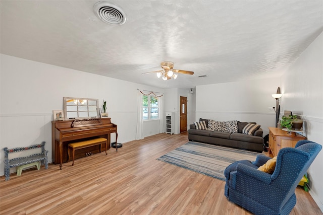living area with ceiling fan, light wood-style flooring, and visible vents
