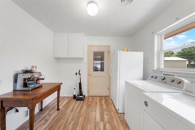 washroom with baseboards, visible vents, light wood finished floors, and washing machine and clothes dryer