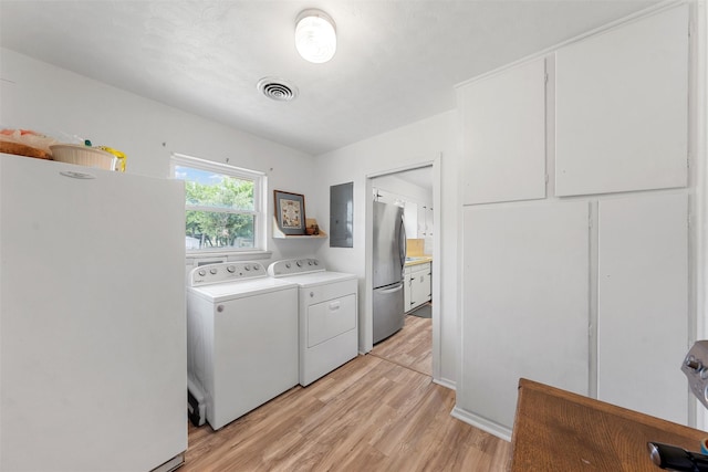 laundry area with visible vents, laundry area, light wood finished floors, and washer and dryer