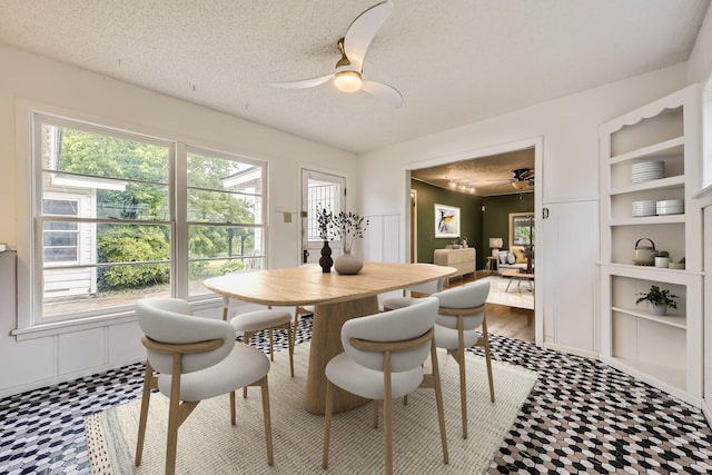 dining space with a textured ceiling, ceiling fan, built in features, and tile patterned floors