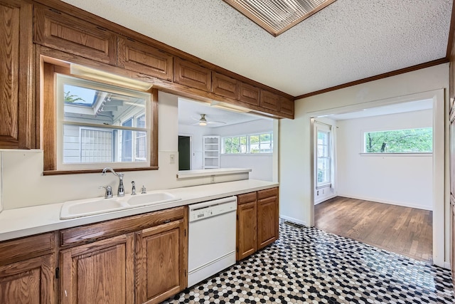kitchen with brown cabinetry, dishwasher, a sink, tile patterned floors, and light countertops