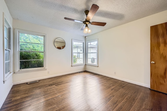 spare room featuring a textured ceiling, a healthy amount of sunlight, and wood finished floors