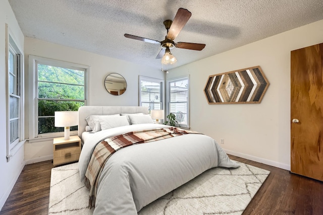bedroom featuring baseboards, multiple windows, and wood finished floors