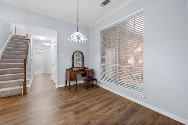 dining area featuring visible vents, wood finished floors, baseboards, ornamental molding, and stairs