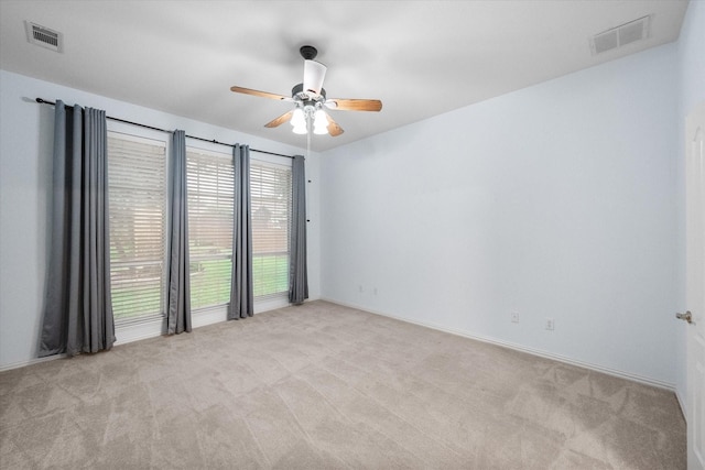 carpeted empty room with visible vents, baseboards, and ceiling fan
