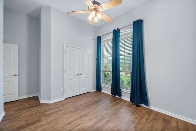 unfurnished room featuring baseboards, ceiling fan, and wood finished floors