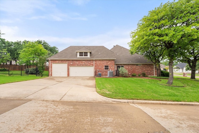 view of front of home with driveway, a front yard, brick siding, central AC, and fence