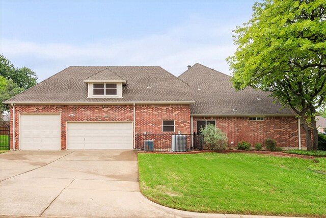 back of house with a sunroom, brick siding, fence, a yard, and a shingled roof