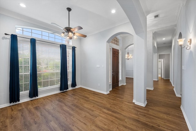 interior space featuring arched walkways, baseboards, ornamental molding, and ceiling fan with notable chandelier