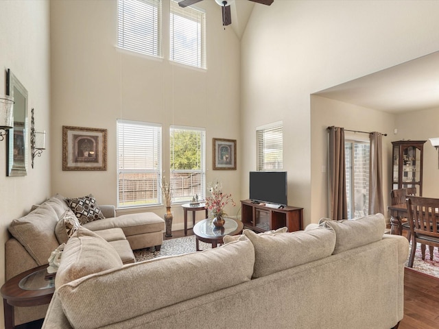 living area with a high ceiling, dark wood finished floors, and ceiling fan