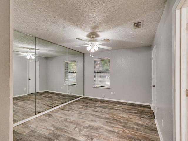 5005 Drew Ct, Arlington, TX 76017 - unfurnished bedroom featuring a textured ceiling, visible vents, wood finished floors, baseboards, and a closet