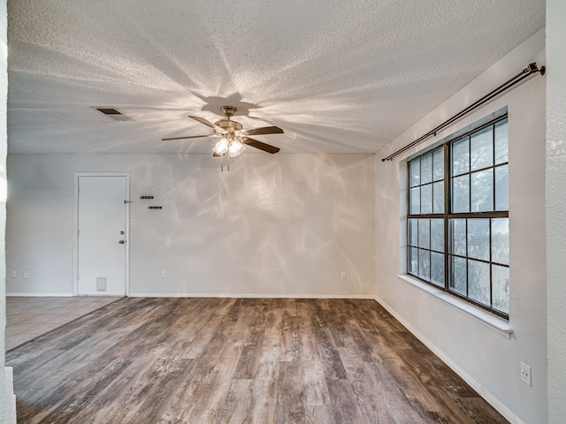 5005 Drew Ct, Arlington, TX 76017 - spare room featuring visible vents, wood finished floors, baseboards, ceiling fan, and a textured ceiling