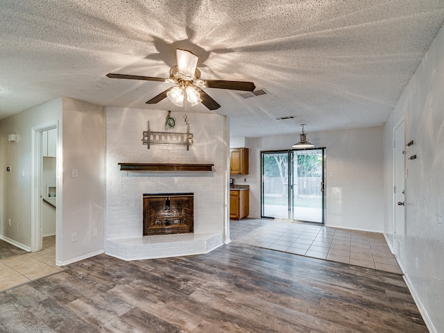 5005 Drew Ct, Arlington, TX 76017 - unfurnished living room with visible vents, a brick fireplace, ceiling fan, and wood finished floors