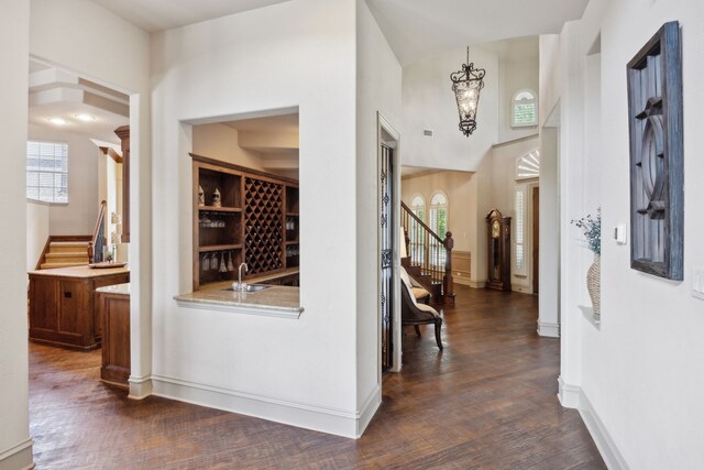 1041 Bandelier Dr, Allen, TX 75013 - kitchen featuring built in appliances, wall chimney range hood, brown cabinetry, decorative backsplash, and a center island