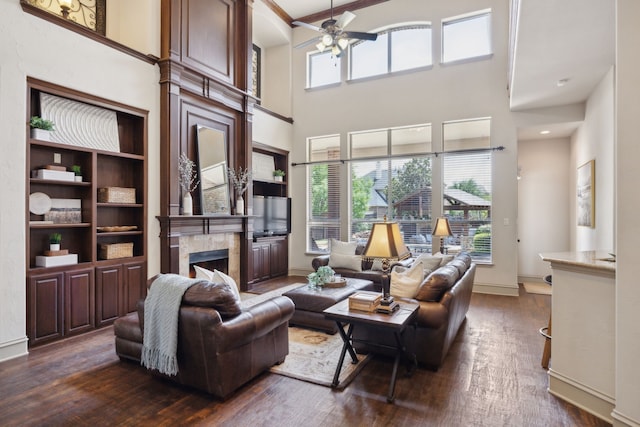 1041 Bandelier Dr, Allen, TX 75013 - living room with ceiling fan, a fireplace, dark wood-type flooring, a towering ceiling, and baseboards