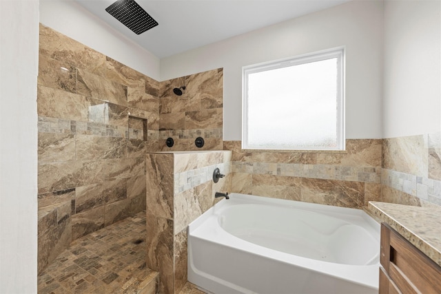 full bath featuring a tile shower, a garden tub, and vanity