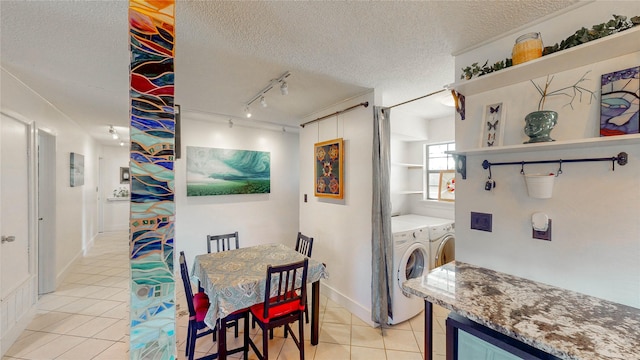 laundry room featuring laundry area, a textured ceiling, light tile patterned floors, and washer and dryer
