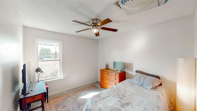carpeted bedroom featuring a ceiling fan, baseboards, and a textured ceiling