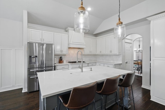 kitchen featuring light countertops, stainless steel appliances, lofted ceiling, and dark wood-type flooring