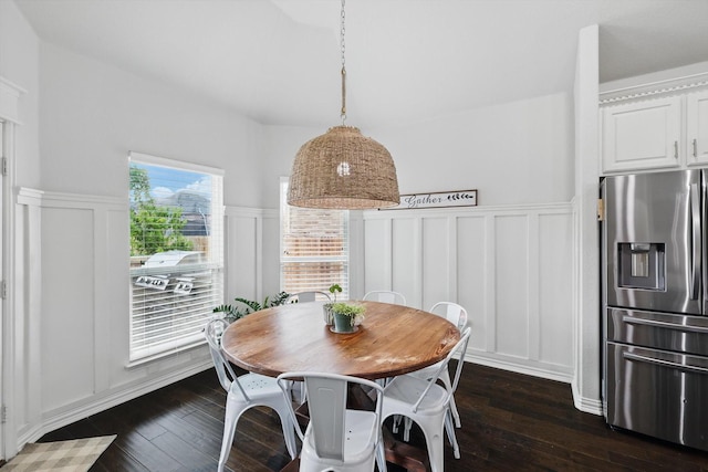 dining area featuring dark wood-type flooring and a decorative wall