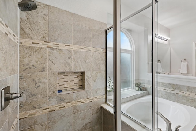 bathroom featuring a tile shower and a bath