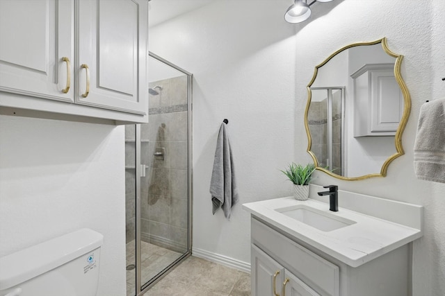 full bath with tile patterned flooring, vanity, toilet, baseboards, and tiled shower