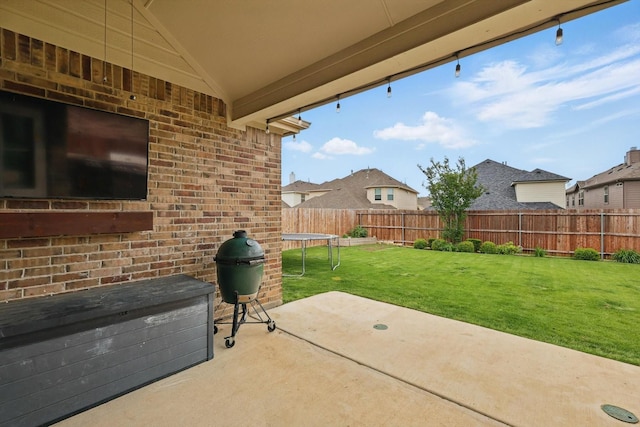 view of patio with a fenced backyard and a trampoline