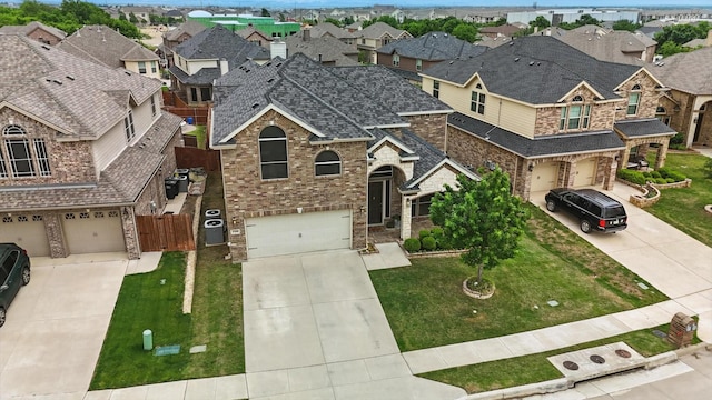 traditional-style house with concrete driveway, brick siding, a shingled roof, and a garage