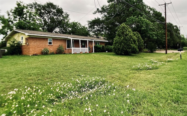 exterior space with a yard, a porch, and brick siding