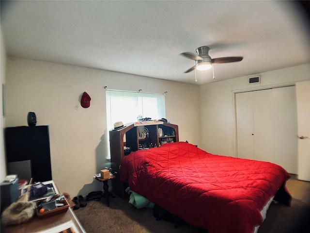 carpeted bedroom featuring a closet, a ceiling fan, and visible vents