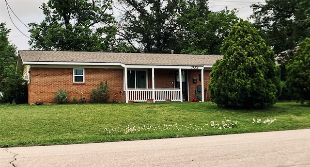 ranch-style house featuring a porch, a front lawn, and brick siding