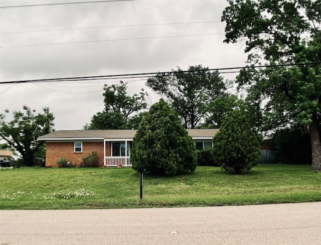 view of front of house with brick siding and a front lawn
