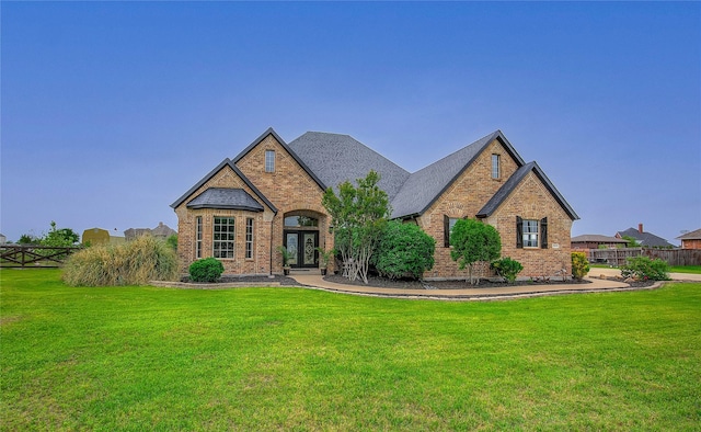 craftsman house with brick siding, a front lawn, and french doors