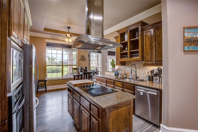 kitchen with baseboards, island range hood, tasteful backsplash, a sink, and black appliances