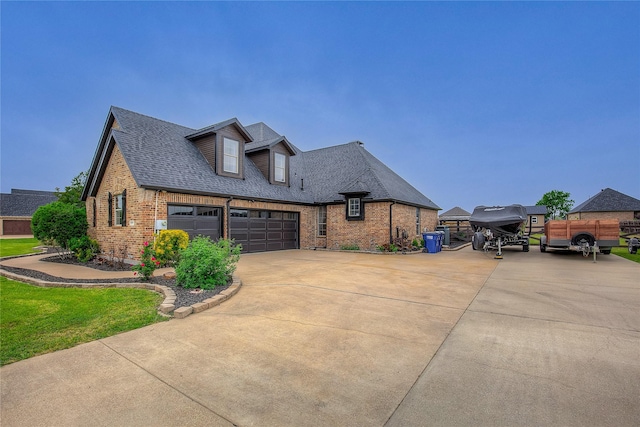 view of front of house featuring brick siding, a garage, roof with shingles, and concrete driveway