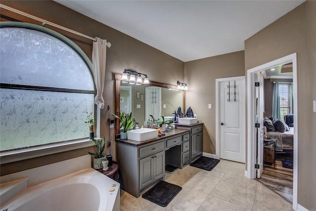 bathroom with ensuite bathroom, a garden tub, and vanity