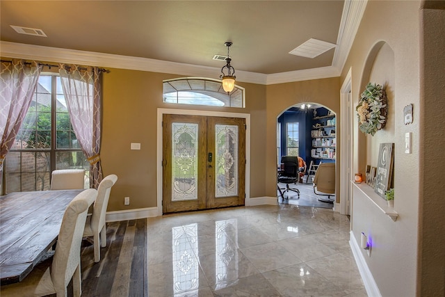 foyer entrance featuring arched walkways, french doors, and a wealth of natural light