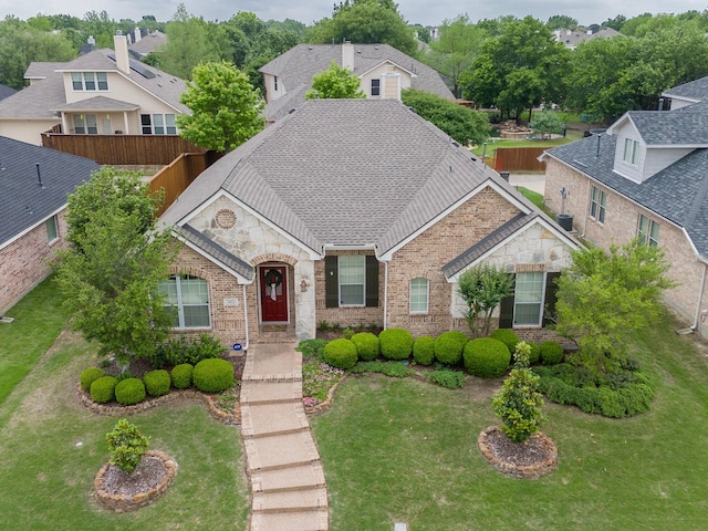 view of front of home featuring brick siding, stone siding, and a front yard