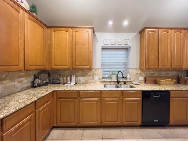 kitchen featuring light stone counters, a sink, black dishwasher, light tile patterned floors, and tasteful backsplash