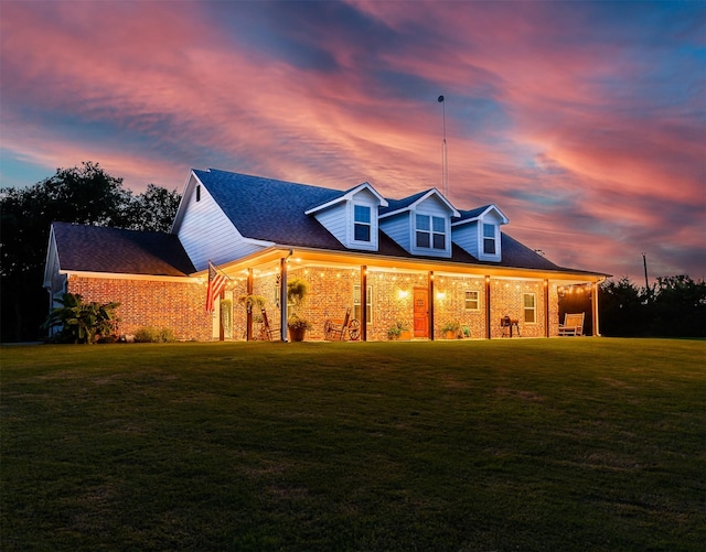 view of front facade with a yard and brick siding