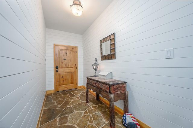doorway with wooden walls and stone floors