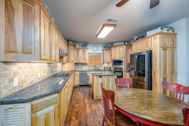 kitchen featuring dark wood-style flooring, visible vents, tasteful backsplash, a sink, and stainless steel appliances