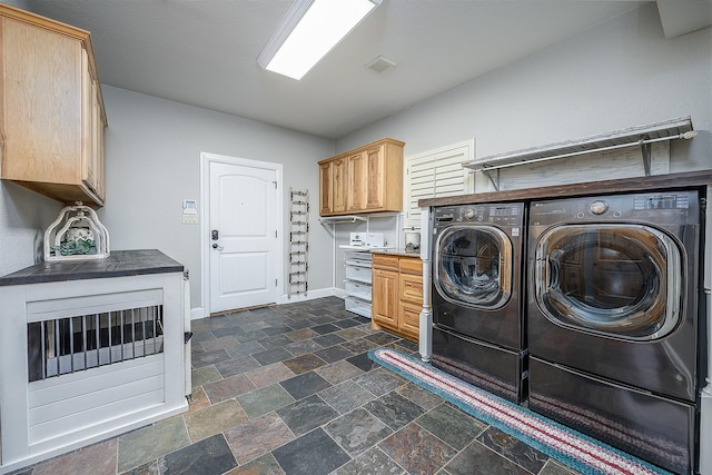 clothes washing area with visible vents, washer and dryer, baseboards, cabinet space, and stone finish flooring