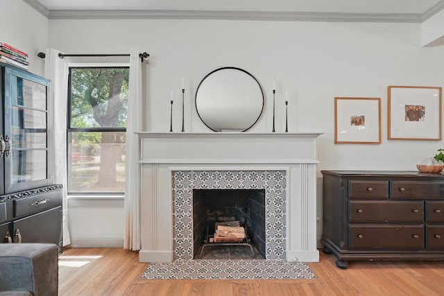 1202 Grand Ave, Abilene, TX 79605 - living room featuring light wood-style flooring, crown molding, and a tile fireplace