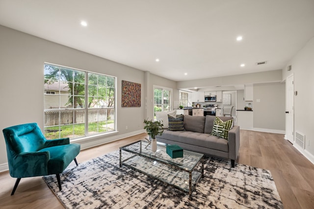 living room with visible vents and light wood-style flooring