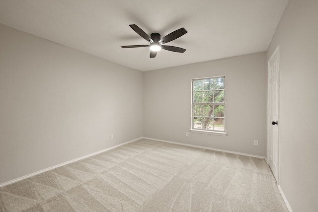 unfurnished room with a ceiling fan, baseboards, and light colored carpet