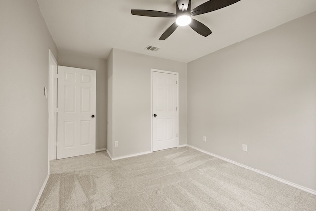 unfurnished bedroom with baseboards, visible vents, light carpet, and ceiling fan