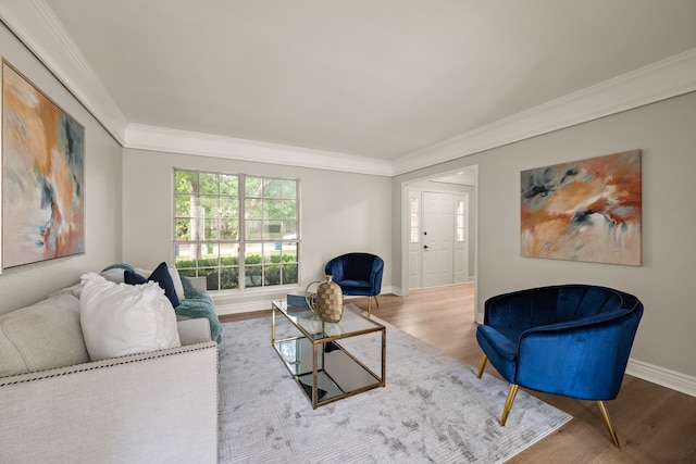 living area featuring baseboards, ornamental molding, and wood finished floors