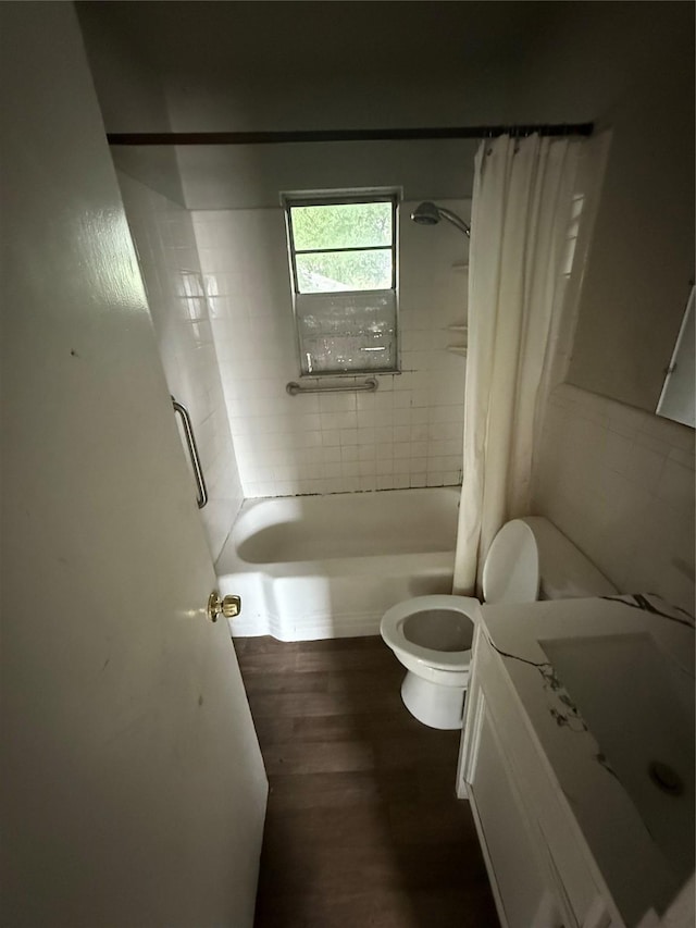 bathroom featuring vanity, toilet, wood finished floors, and shower / tub combo with curtain